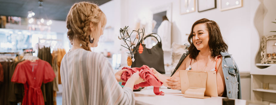  Image of a shop owner taking a card payment with an EFTPOS machine.