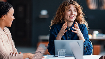 Group of professionals engaged in a collaborative meeting in a modern office space, showcasing teamwork and innovation. The participants appear focused and engaged, exchanging ideas and strategies.