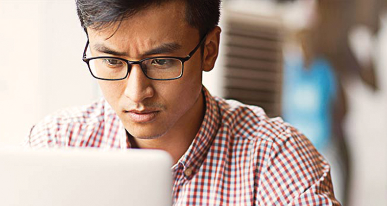 Unemployed man on a computer reading a guide to managing job loss