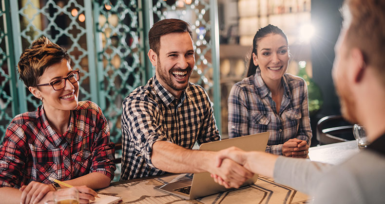 Person shaking hands with the interview panel after receiving a job offer